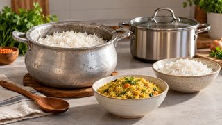 Symbolbild: unbeschichteter handwerklicher Aluminiumtopf neben Reis, Holzlöffel und geprüftem Kochgeschirr auf einer Küchenfläche