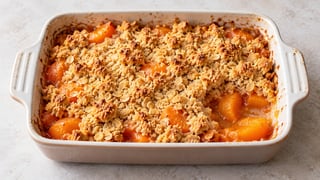 Abricots sous des miettes dorées au beurre et avoine dans un plat bas
