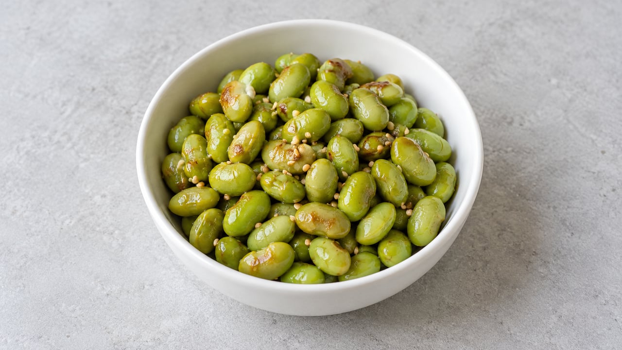 Edamame cocido verde suave con sésamo tostado en cuenco