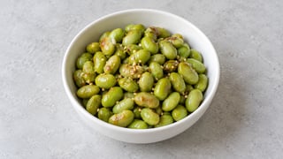 Edamame cuits verdâtres au sésame grillé dans un petit bol