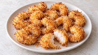 Gambas al coco doradas, una abierta con interior cocido opaco