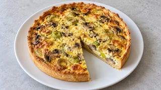 Quiche pequeña cortada con puerro, setas y relleno dorado
