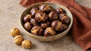Marons arrosto e parzialmente pelato dalla friggitrice ad aria su un panno autunnale