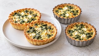 Cuatro miniquiches de masa dorada con espinacas y feta