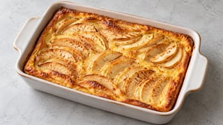 Tortita dorada con láminas finas de manzana en un recipiente bajo