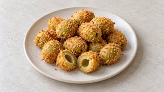 Piccole olive impanate dorate con cuore verde al taglio