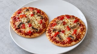 Pizzas pita pequeñas con pimiento rojo, setas y mozzarella fundida