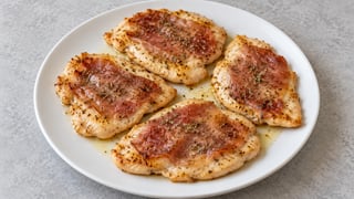 Quattro fettine piatte di pollo cotto con prosciutto dorato