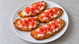 Láminas de batata con queso crema blanco y tomate picado