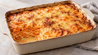 Gratén de batata con capas naranjas y costra de queso dorada