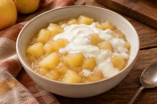 Postre dorado de dados de manzana pelada en jugo espeso con yogur natural blanco