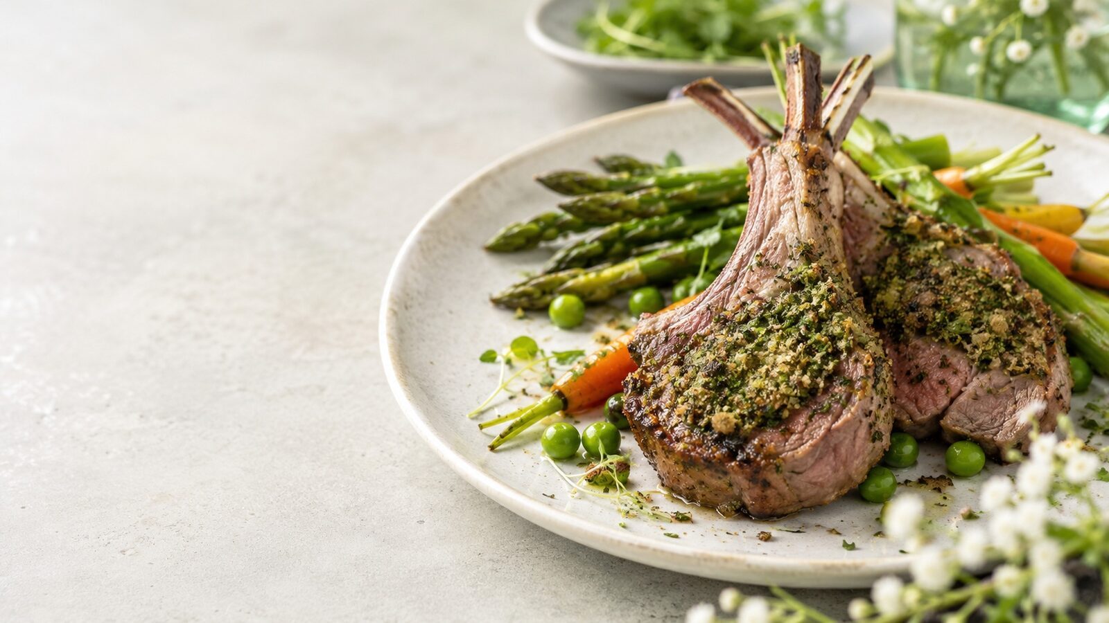 Lammkoteletts mit Kräuterkruste als frisches Frühlingsgericht mit saisonalem Gemüse und Kräutern