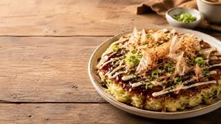 Okonomiyaki mit Sauce, japanischer Mayonnaise, Aonori und Bonitoflocken