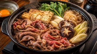 Sukiyaki im flachen Topf mit Rindfleisch, Tofu, Shirataki, Chinakohl, Lauch und Pilzen