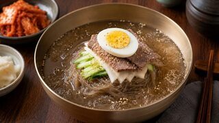 Mul Naengmyeon with buckwheat noodles in ice-cold broth, cucumber, pear, radish, beef and egg