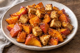 Roasted orange skin-on Hokkaido cubes and golden tofu cubes scattered with pale sesame seeds