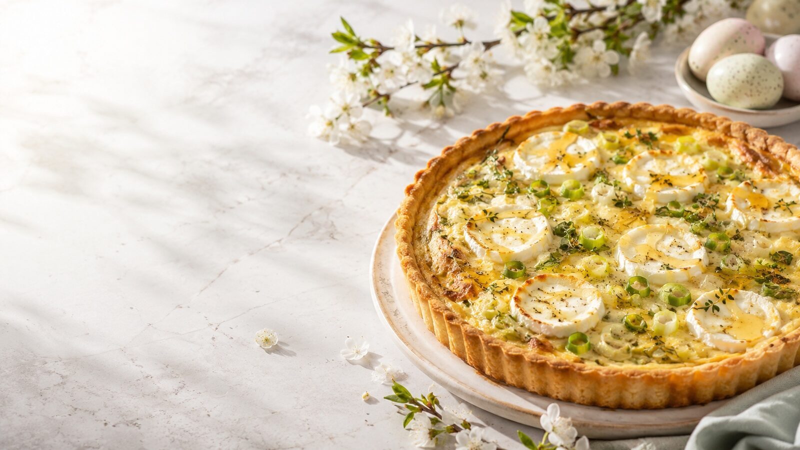 Ziegenkäse-Tarte mit Frühlingszwiebeln als liebevoll angerichtetes Osternrezept für Brunch, Feiertage und Familienessen