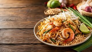 Pad Thai mit Reisnudeln, Garnelen, Ei, Sojasprossen, Erdnüssen und Limette