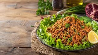 Kisir Bulgursalat mit Petersilie, Frühlingszwiebeln, Zitrone und Salatblättern
